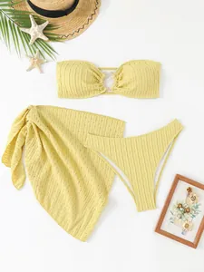 Detail of yellow three-piece bikini set with textured fabric and matching sarong