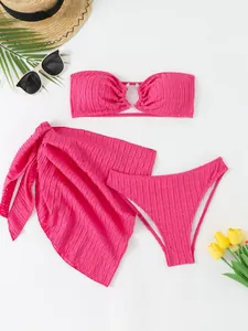 Detail shot of a vibrant hot pink three-piece bikini set with a matching wrap skirt.