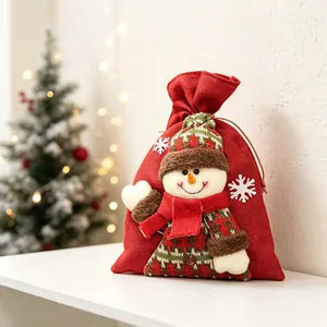 Détail d'un sac cadeau de Noël en toile rouge avec un personnage de bonhomme de neige.