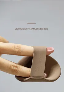 Detailed view of an oval makeup powder puff featuring a brown seamless finger ribbon
