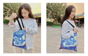 Woman carrying canvas tote bag with Van Gogh Starry Night oil painting print detail.
