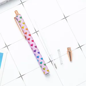 Retractable purple glitter ballpoint pen with colorful heart patterns and internal components