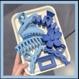 Elegant blue matte hair claw clip set featuring flower and geometric shapes in a white tray