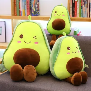 Adorable soft avocado plush toy pillows in three different sizes on a grey sofa