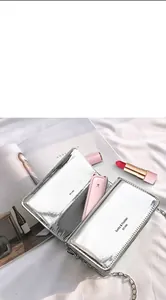 Close-up of a portable pink kitten folding fan inside a silver bag next to a lipstick.