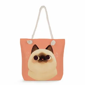 Detail view of a cartoon Siamese cat print on a peach-colored canvas beach tote bag