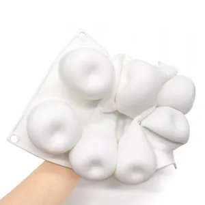 Flexible white fruit-shaped silicone mousse cake mold being squeezed to show elasticity
