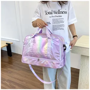 Model holding holographic iridescent purple duffel bag with wet/dry separation compartment