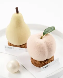 Close-up detail of realistic pear and peach fruit mousse cakes with velvet spray texture