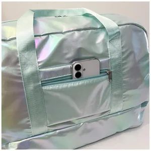 Detail view of holographic travel bag showing the front zipper pocket with phone