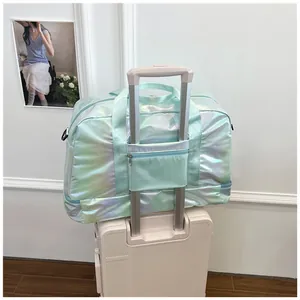 Close-up of holographic mint green travel bag attached to a white suitcase handle