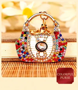 Close-up of a colorful rhinestone-encrusted handbag-shaped keychain on a bamboo mat