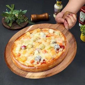 Close-up of acacia wood pizza peel tray held by hand with fruit pizza