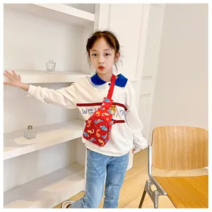 Close-up of child wearing red cartoon dinosaur chest bag in a lifestyle setting