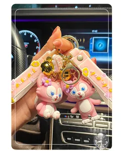 Close-up of pink cartoon character keychain with bell and 'cute' silicone strap