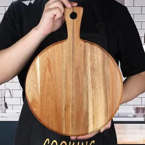 Close-up of a handcrafted round acacia wood cutting board with a convenient handle.
