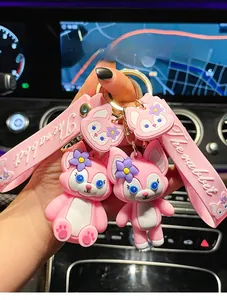Close-up of pink LinaBell cartoon keychain with rabbit strap in car interior.