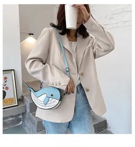 Woman wearing a cute blue and white whale-shaped crossbody bag in a lifestyle setting.