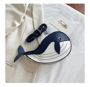 Close-up detail of a cute cartoon whale-shaped crossbody bag in blue and white