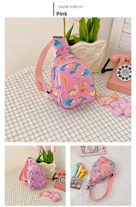 Pink children's cartoon dinosaur sling bag with adjustable strap and cute prop arrangement