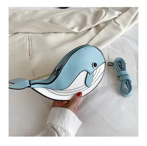 Close-up of a cute blue and white whale-shaped crossbody bag with matching strap.