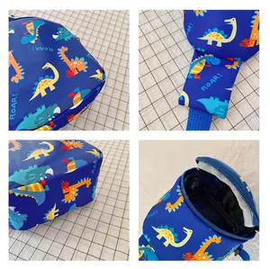Detailed view of children's blue chest bag with colorful dinosaur prints and zipper.