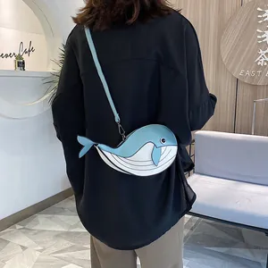 Detail view of a cute cartoon whale-shaped crossbody bag in blue and white color block