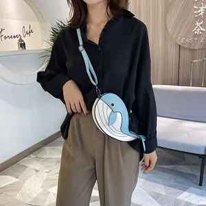 Detailed view of a cute light blue whale-shaped crossbody bag worn by a model