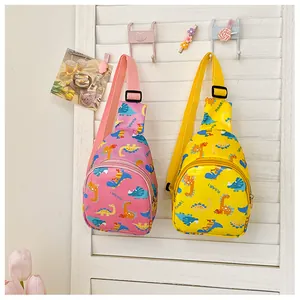 Cartoon dinosaur chest bags for kids in pink and yellow shown hanging on a white wall