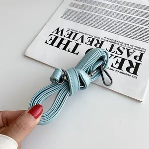 Detail of light blue adjustable strap for whale crossbody bag with dark metal hooks