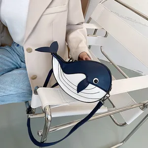 Detail view of a cute cartoon whale shaped crossbody bag in navy and white finish