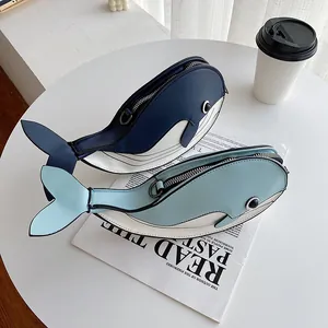 Detail view of two cute whale-shaped crossbody bags in navy blue and light blue colors