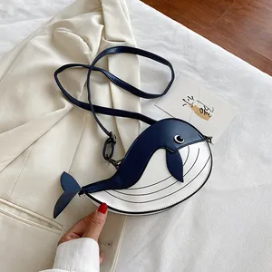 Detailed view of a cute cartoon whale-shaped crossbody bag in navy and white