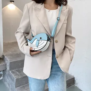 Close-up detail shot of a cute cartoon whale-shaped crossbody bag in blue and white colors
