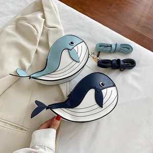 Detailed view of two cute cartoon whale crossbody bags in light blue and navy