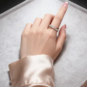 Elegant two-tone X-shaped ring with micro-set zircon stones worn on a model's hand