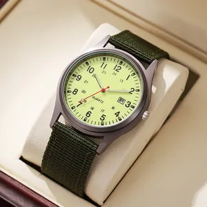 Close-up of men's military style quartz watch with green canvas strap and date display
