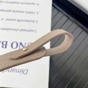 Close-up of adjustable PU leather handbag strap with gold rivet and pebble grain texture