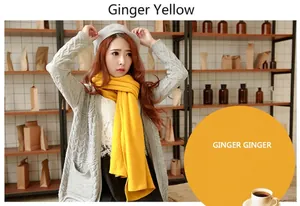 Detail showing a vibrant ginger yellow scarf worn with a grey cardigan and beret.
