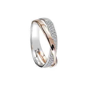 Two-tone X-shaped criss-cross ring with zircon micro-paving in a minimalist luxury style.