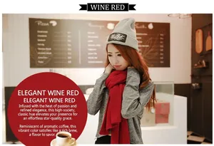 Detail of a bright wine red soft cashmere-like scarf worn by a model in a cafe setting