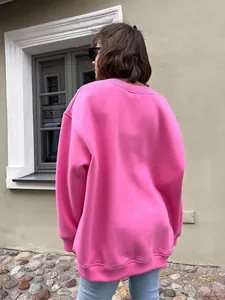 Detailed back view of a pink oversized crewneck sweatshirt in a realistic street scene