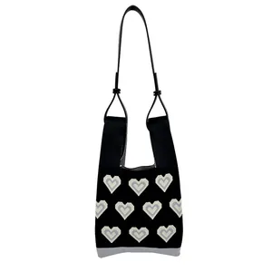 Knitted shoulder bag with heart pattern and adjustable black PU leather strap