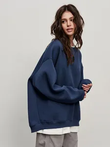 Detail view of a navy blue oversized crewneck sweatshirt on a model for a streetwear look