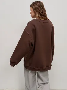 Detailed rear view of a women's oversized brown crewneck sweatshirt in casual street style