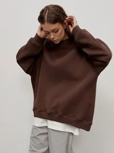 Detailed view of a brown oversized round neck sweatshirt for women in minimalist street style.