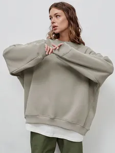 Detail view of a loose oversized solid color round neck sweatshirt in khaki green