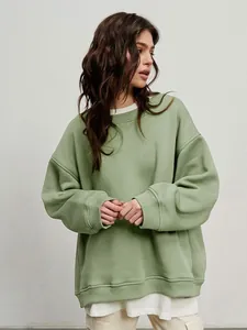 Detail view of women's oversized sage green crewneck pullover sweatshirt on model