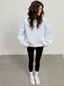 Full body shot of a model wearing an oversized light blue crewneck fleece sweatshirt
