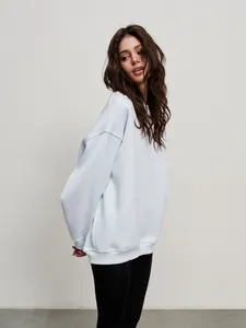 Side view of a comfortable women's light blue oversize crewneck street style sweatshirt